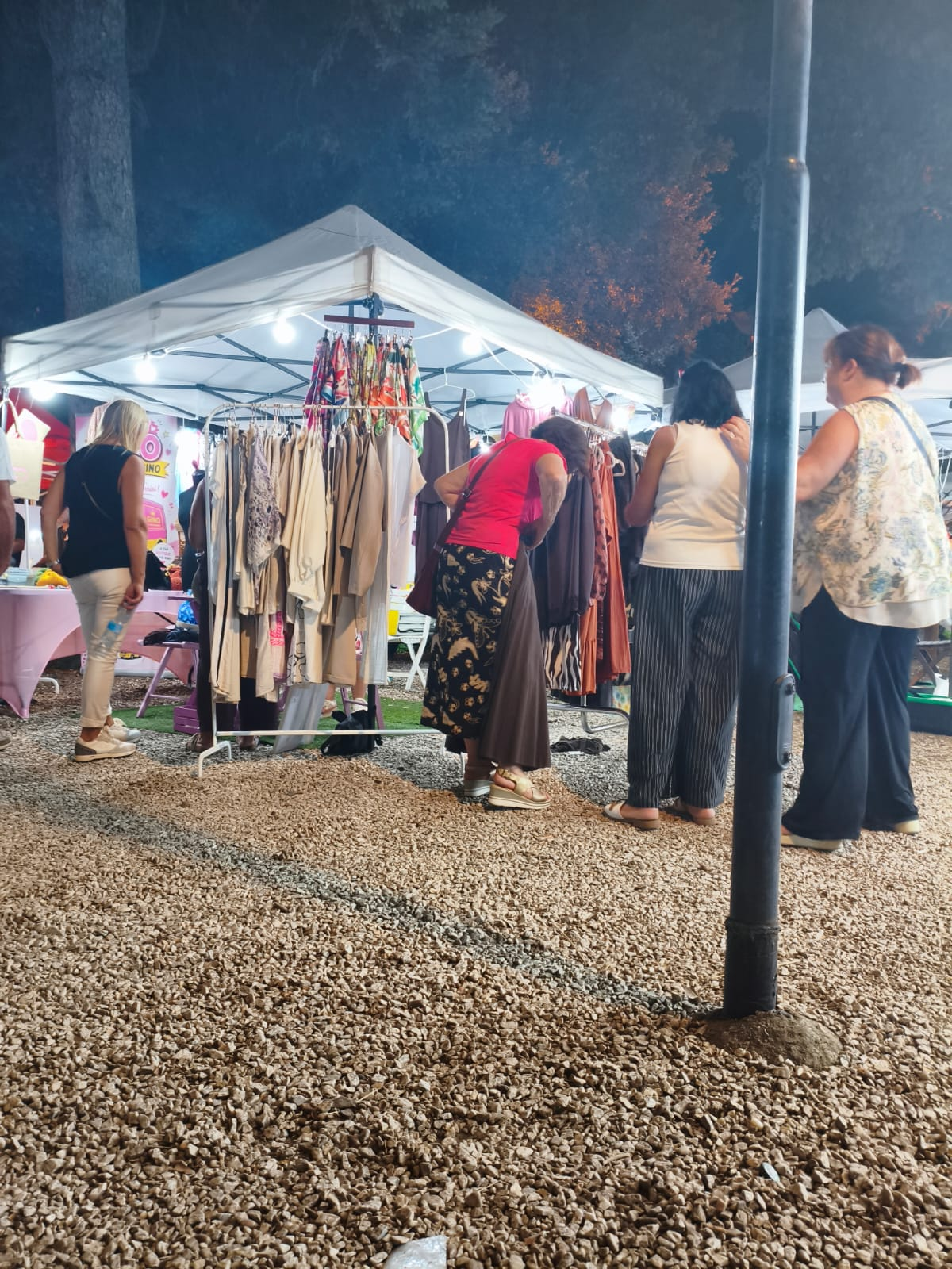 Clienti che osservano gli abiti esposti allo stand